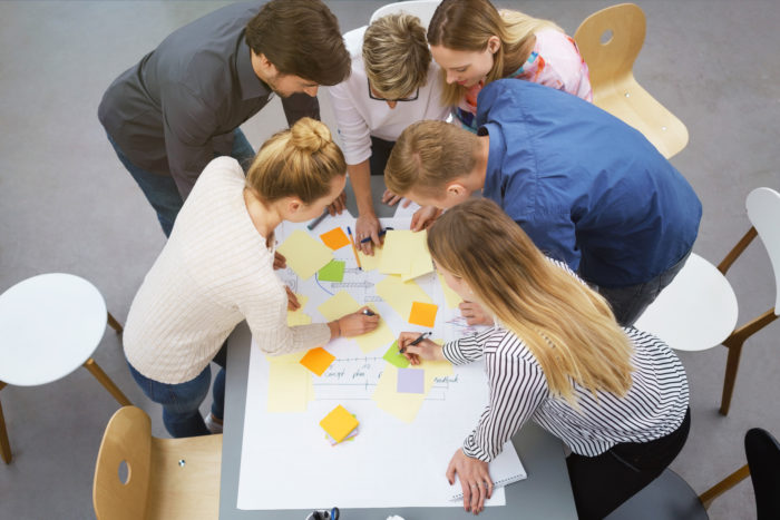 teilnehmer in einem workshop machen notizen auf bunten zetteln